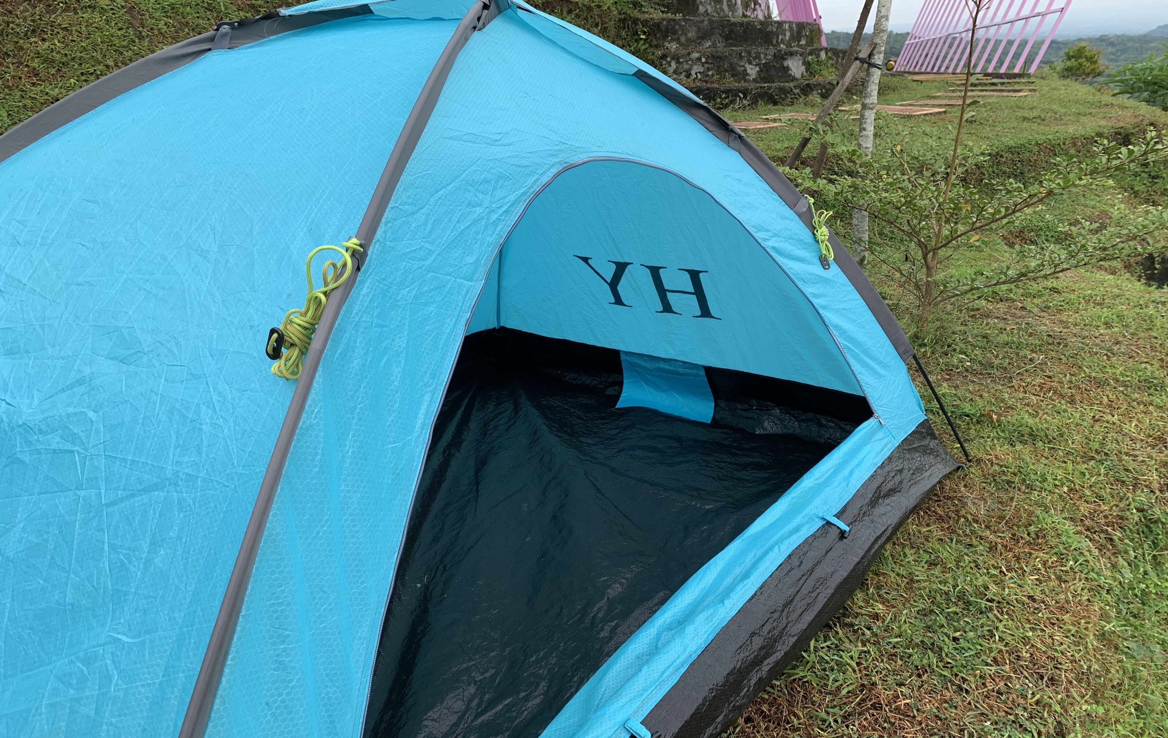Une tente bleue avec les lettres « YH » sur l’entrée.