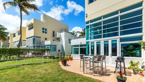 Un edificio moderno con un patio amoblado y plantas en macetas.
