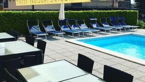 A poolside area with lounge chairs and tables, a clear pool, and a sign reading "LAKESIDE HOLIDAY RESORT". - Lakeside Apartment with a swimming pool, free parking, and free Wi-Fi (Domaso)