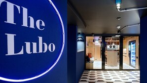 L’entrée d’un hôtel, avec un mur bleu et une enseigne indiquant « The Lucho ».
