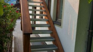 A wooden staircase with metal steps leading up to a building.