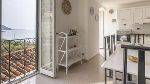 A spacious kitchen with a view of the sea, a dining area, and a white shelving unit. - Bella Vista by Interhome (Ventimiglia)