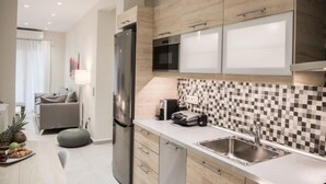 A modern kitchen with a stainless steel refrigerator, microwave, and double sink.