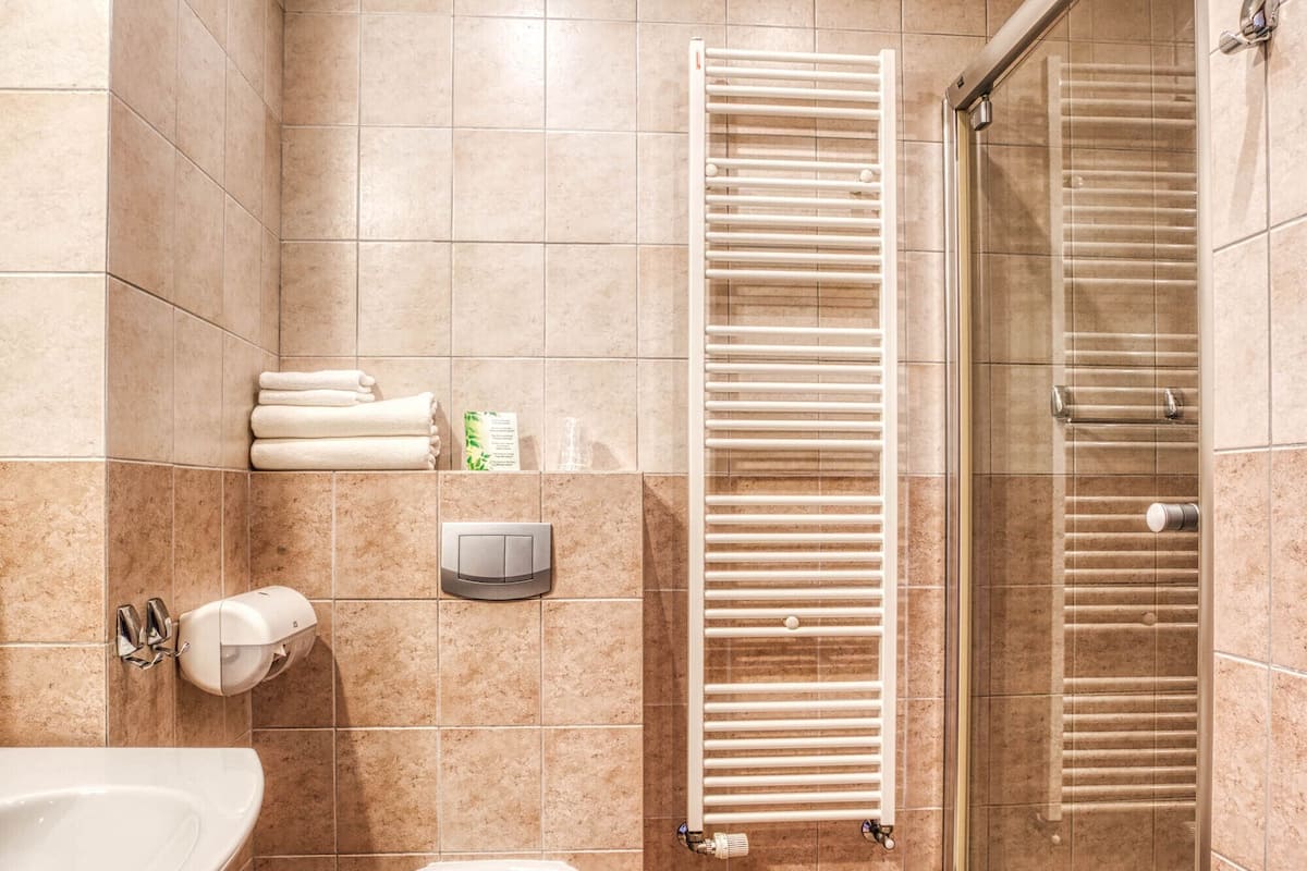 A bathroom with a bathtub, toilet, and glass-enclosed shower.