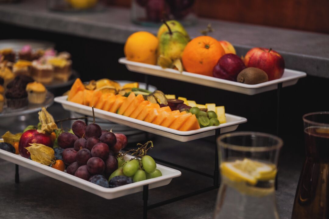 Un buffet proposant une variété de fruits et de pâtisseries.