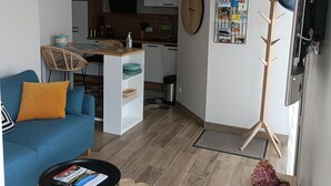 Ein modernes Wohnzimmer mit Sofa, Couchtisch und einer Küche im Hintergrund.