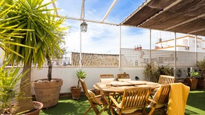 An outdoor patio with a round wooden table, chairs, and potted plants. - Real Carretería. 3 bedrooms, 3 bathrooms, terrace, views (Sevilla)