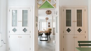 A hallway with white doors, a dining area with a table and chairs, and a green bench. - Real Carretería. 3 bedrooms, 3 bathrooms, terrace, views (Sevilla)