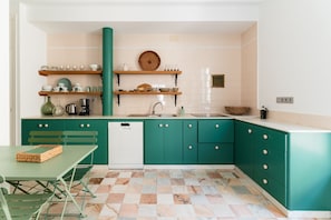 A kitchen with teal cabinets, a white countertop, and a checkered floor. - Real Carretería. 3 bedrooms, 3 bathrooms, terrace, views (Sevilla)