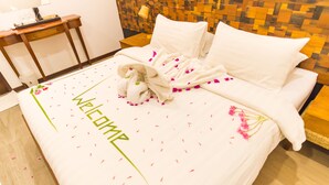 A hotel room with a neatly made bed, a bedside table with a lamp, and a wall with a mosaic pattern. - Premier Beach (Gulhi)