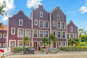 A multi-story building with a symmetrical facade, featuring a series of windows and doors.