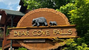 Señal para Bear Cove Falls, un complejo turístico administrado por Dollywood, que presenta una escultura de un oso y su cachorro.