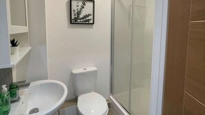 Ein Badezimmer mit Toilette, Waschbecken und Dusche.