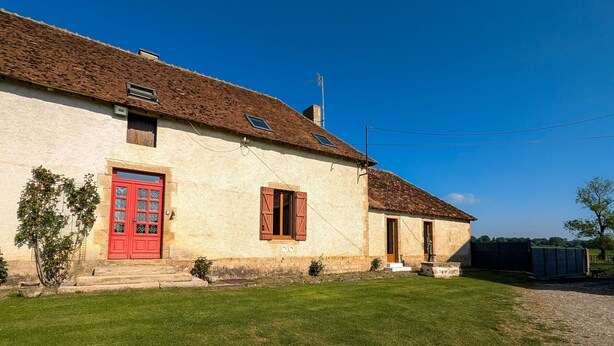 A rustic building with a red door and a small garden in front. - Charming Farmhouse Retreat with Enclosed Garden, A/C, and Farm Tours in Berry (Cluis)
