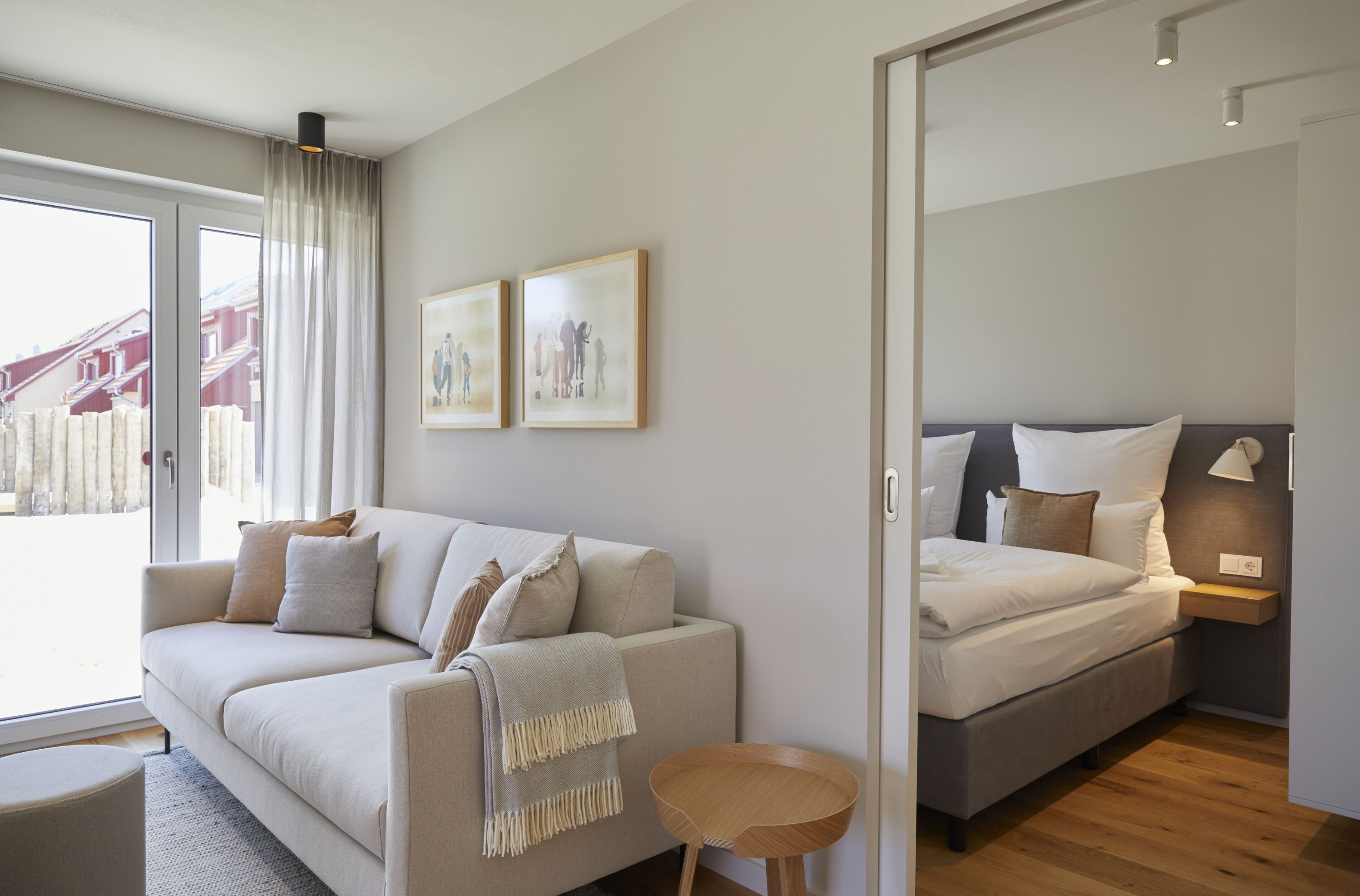 Een moderne slaapkamer met een bank, een bed en twee ingelijste foto's aan de muur.