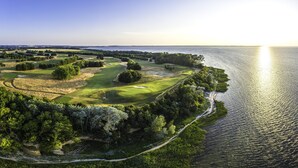 Ein Golfplatz an der Küste mit angrenzendem Gewässer.