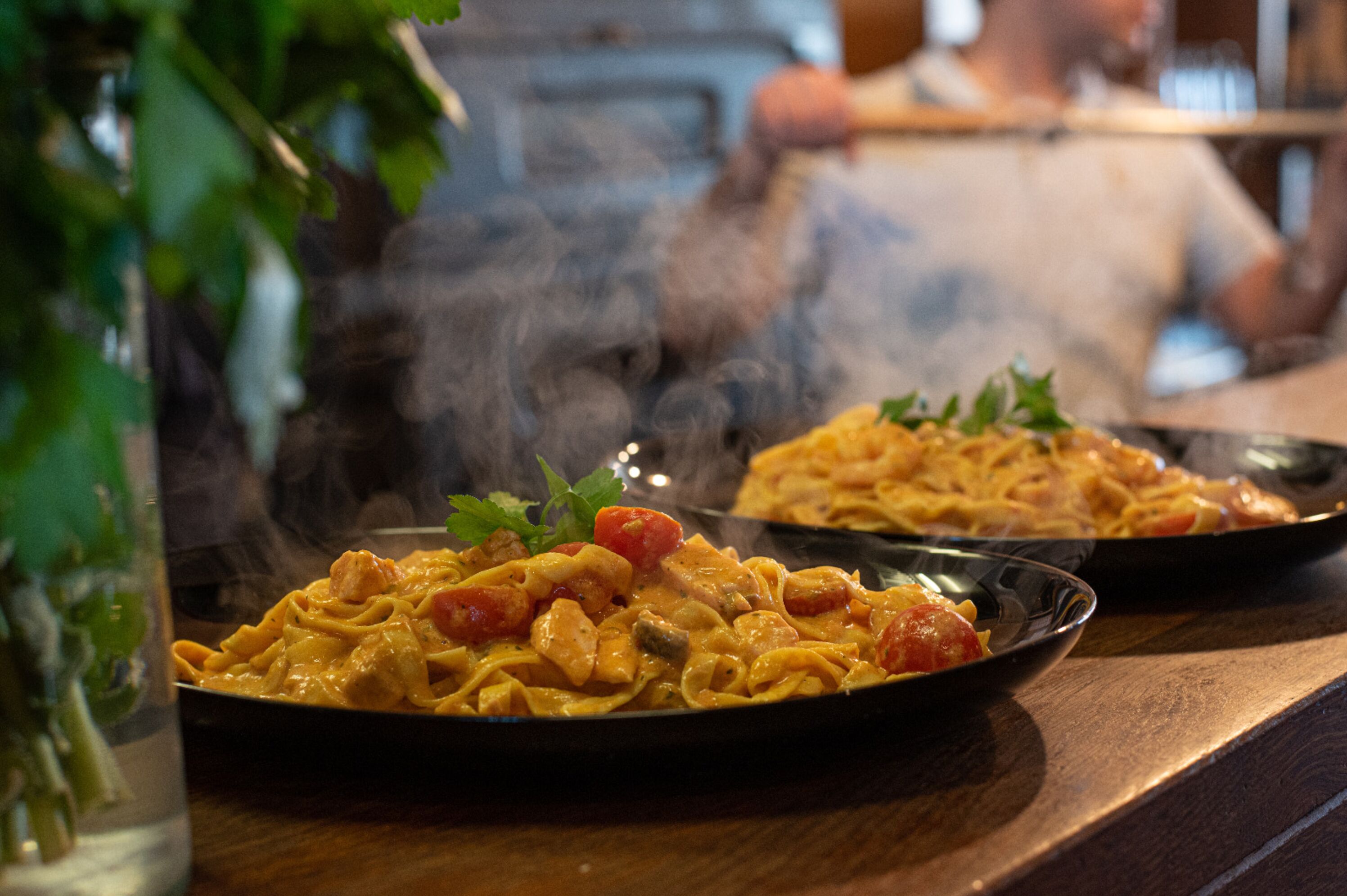 Una mesa de comedor con dos platos de pasta.