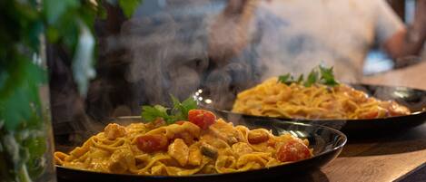 Una mesa de comedor con dos platos de pasta.