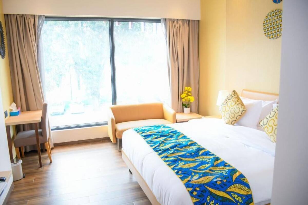 Habitació d'hotel amb un llit, un escriptori i una cadira.
