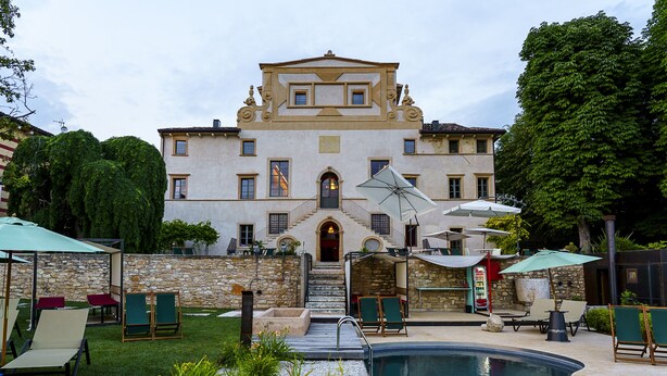 A large building with a swimming pool, outdoor seating, and a stone wall. - Villa Balis Crema (Grezzana)