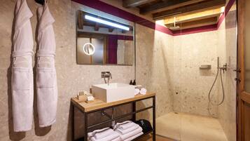 Ein modernes Badezimmer mit einem Holzwaschtisch, einem großen Spiegel und einer bodengleichen Dusche.