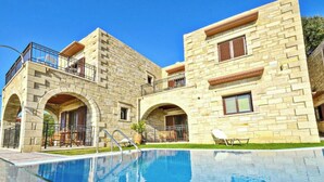 Edificio de piedra con piscina, con arcos y balcones.