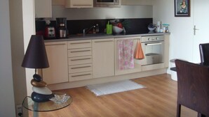 Een kleine keuken met een magnetron, oven en koffiezetapparaat.