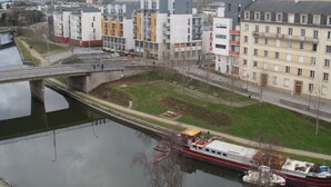 Een rivier met een brug en gebouwen op de achtergrond.