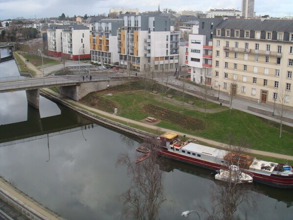 A river with a bridge and buildings in the background. - Cozy bedroom in the heart of Rennes (Rennes)