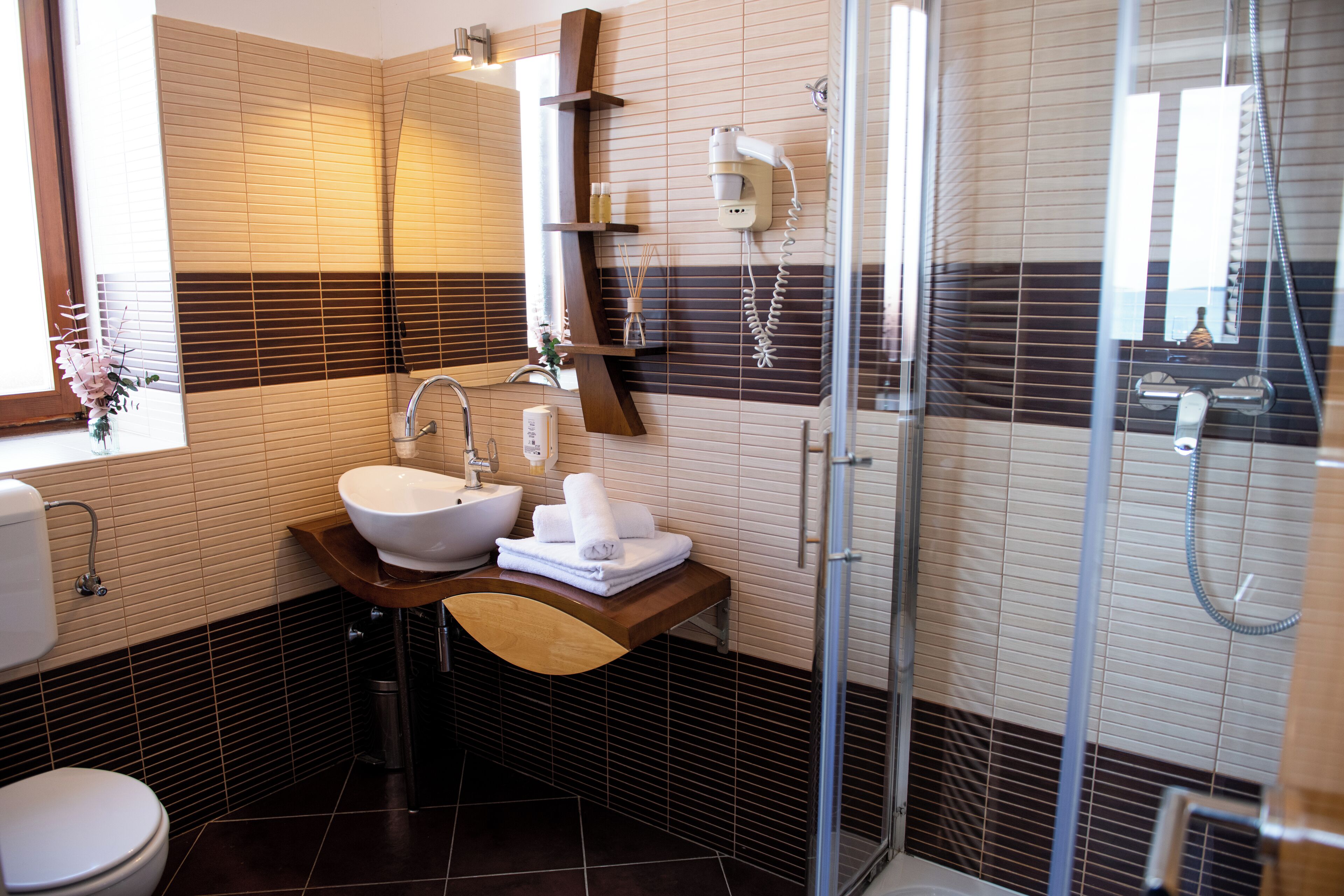 Een moderne badkamer met een wastafel, spiegel en douche.