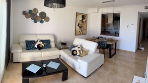 Ein modernes Wohnzimmer mit einer Sofagarnitur, einem Couchtisch und einem Essbereich mit Tisch und Stühlen.