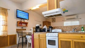 Eine Küche mit Herd, Mikrowelle und Fernseher an der Wand.