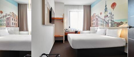 A hotel room with two beds, a desk, a chair, and a large window.