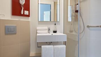 A modern bathroom with a toilet, sink, and shower.