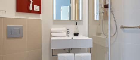 A modern bathroom with a toilet, sink, and shower.