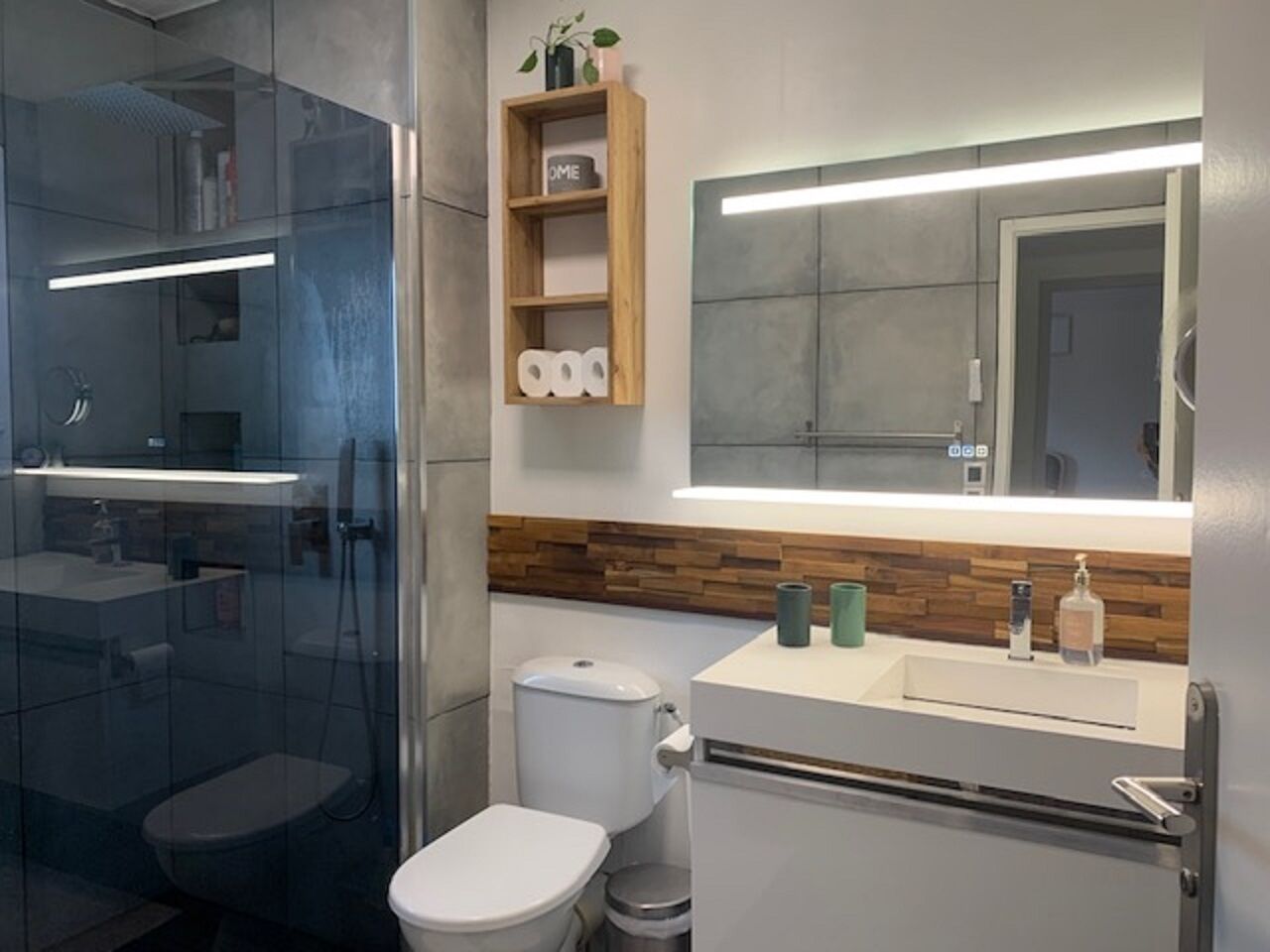 Een bad/douchecombinatie, zeep, toiletpapier