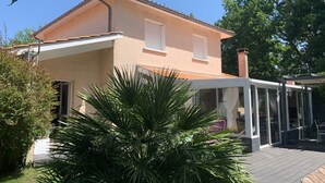 Une maison à deux étages dotée d’un patio couvert.