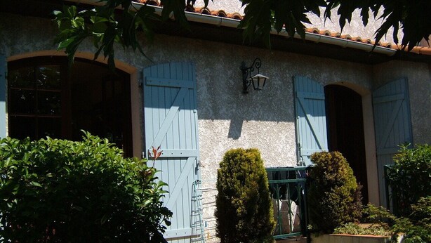 A building with blue shutters, a small staircase, and a garden area with trimmed bushes. - 1 Bedroom Apartment in Le Bouscat (Le Bouscat)