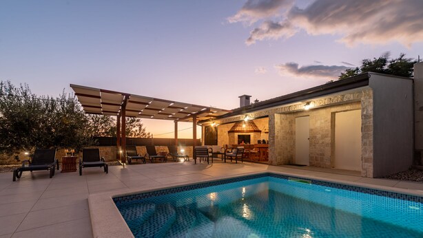 A swimming pool with lounge chairs and a covered patio area. - Villa Petar ZadarVillas (Donji Kašić)