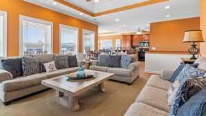A spacious living room with a sofa set, a coffee table, and a ceiling fan.