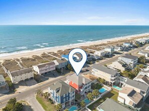 An aerial view of a coastal residential area with houses, a road, and a beach. - Cherry Bomb by Brunswick Vacation Rentals w/ Heated Pool, Elevator, 2nd Row Home (Ocean Isle Beach)