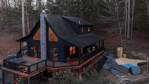 A cabin with a deck, a hot tub, and a stone fireplace. - Mossybrook Hideout: Dog Friendly Oasis in High Falls w/ Hot Tub (High Falls)