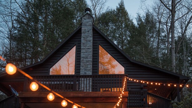 A log cabin with a balcony and string lights. - Mossybrook Hideout: Dog Friendly Oasis in High Falls w/ Hot Tub (High Falls)