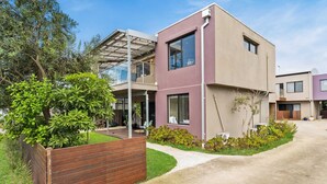 A modern two-story house with a flat roof, large windows, and a well-maintained garden. - Back Beach Beauty in Smiths Beach (Smiths Beach)