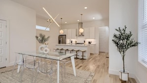 A modern kitchen with a central island, bar stools, and pendant lighting. - 18- Luxe Modern Home- The Music City Collection (Nashville)