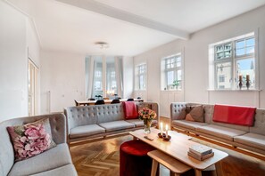 Un salon moderne avec un canapé, une table et une fenêtre avec des rideaux.