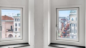 Two windows with views of a cityscape, one showing a building with a red roof and another with a decorated street. - 250 Sqm Smack Bang in the Center of Copenhagen (Copenhagen)