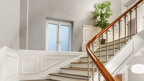 A staircase with white railings and a wooden handrail, leading to a door with a window. - 250 Sqm Smack Bang in the Center of Copenhagen (Copenhagen)