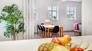 A dining area with a table, chairs, a plant, and fruit on the table. - 250 Sqm Smack Bang in the Center of Copenhagen (Copenhagen)