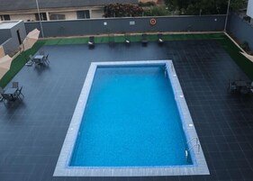 Una piscina al aire libre, camas de piscina gratis, sombrillas